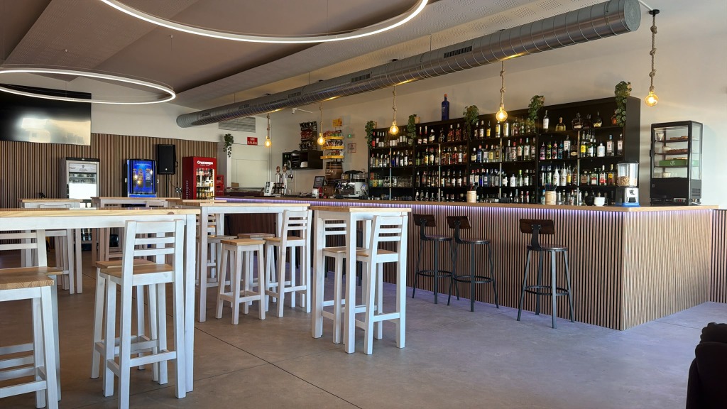 Barra marinera de madera con iluminación suspendida y botillería